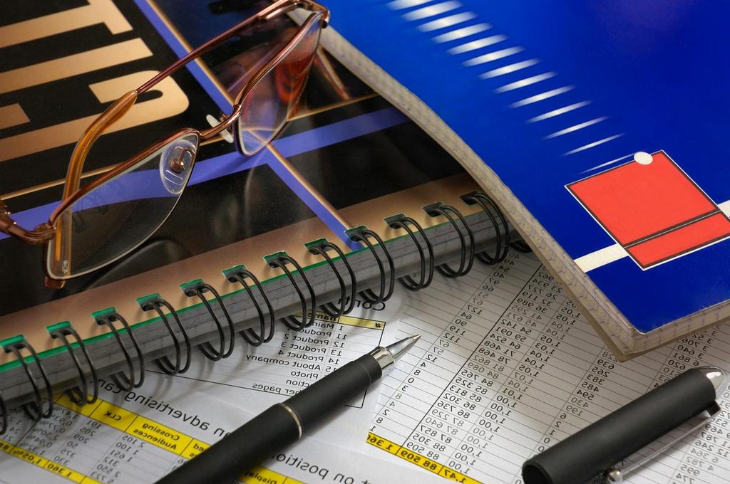 Collection of financial books and online resources on a wooden desk